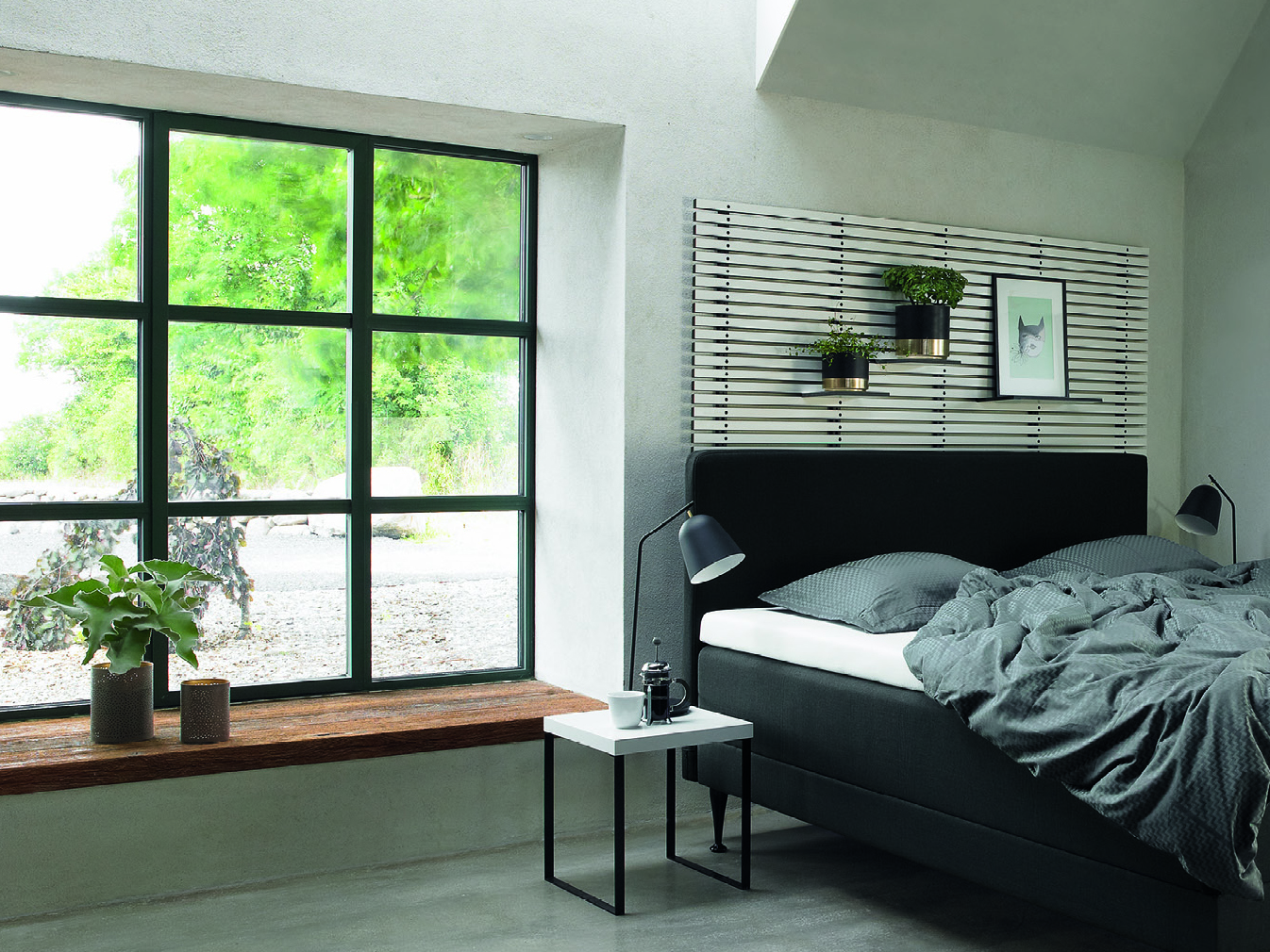 sypialnia z dużym oknem – po prawej stronie łóżko, na łóżku materac, dwie poduszki i pościel
